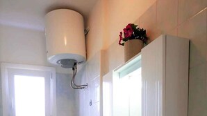 A bathroom with a toilet, bidet, sink, and a window. - Holiday apartment with air conditioning (San Michele al Tagliamento)