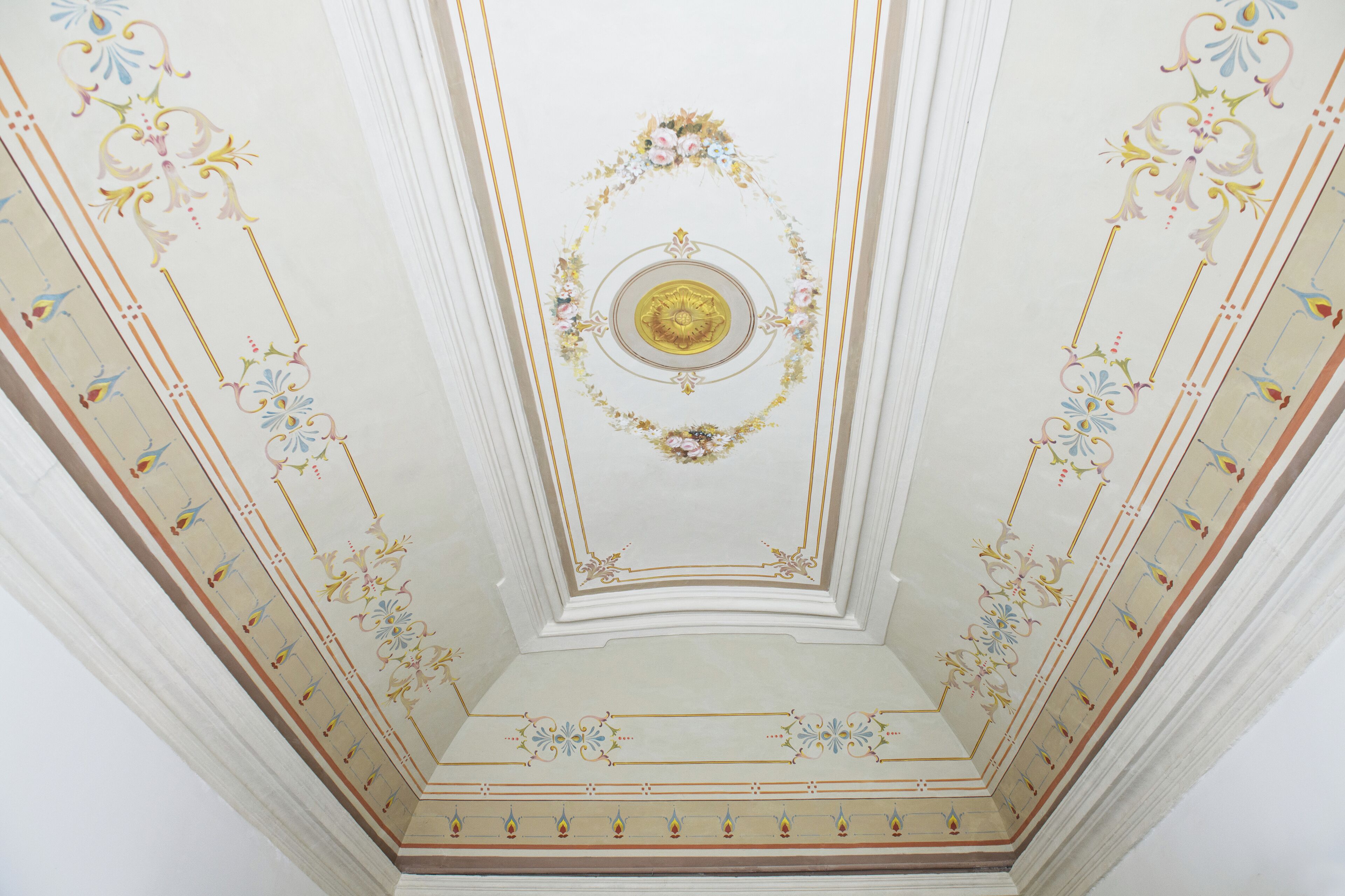 Eine Decke mit aufwändigen floralen und geometrischen Mustern, einer zentralen Medaillon und einem symmetrischen Design.