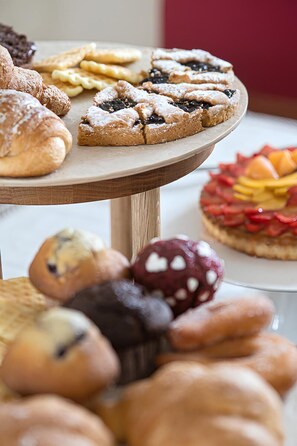 A variety of pastries and desserts on a wooden serving board.
