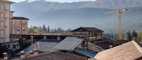 Paisaje montañoso con una grúa de construcción y edificios de arquitectura tradicional.