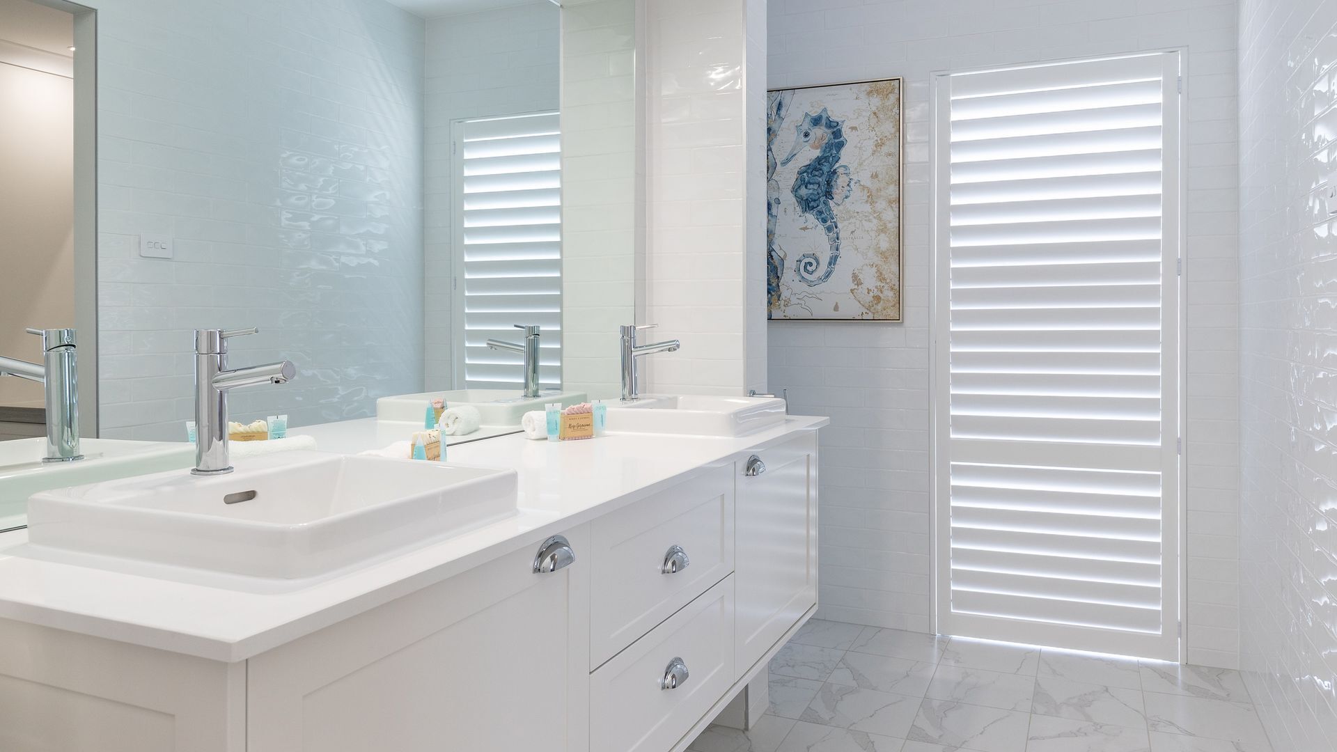 A modern bathroom with a white vanity, two sinks, and a large mirror.