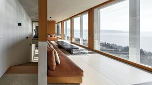 Un intérieur moderne avec un long banc, de grandes fenêtres et une vue sur la mer.