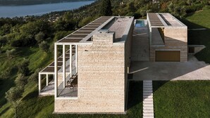 Une maison moderne avec un toit plat, de grandes fenêtres et une piscine.