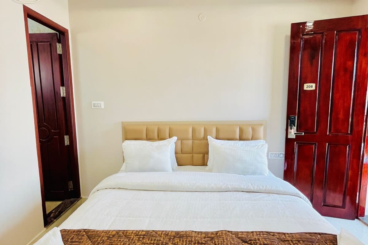 Une chambre d’hôtel avec un lit, un ventilateur de plafond et une porte portant un numéro.