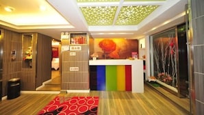 A hotel lobby with a reception desk, a decorative ceiling, and a colorful wall. - Zenghuage(Urban forest)Theme Hotels (Zhenjiang)