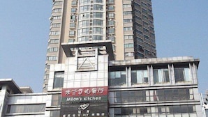 A multi-story building with various commercial establishments on the ground floor, including a restaurant named "Milan's Kitchen". - Zenghuage(Urban forest)Theme Hotels (Zhenjiang)