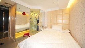 A hotel room with a bed, a mirror, a wardrobe, and a shower area. - Zenghuage(Urban forest)Theme Hotels (Zhenjiang)
