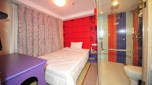 A hotel room with a bed, a desk, a shower with colorful tiles, and a glass-enclosed bathroom. - Zenghuage(Urban forest)Theme Hotels (Zhenjiang)