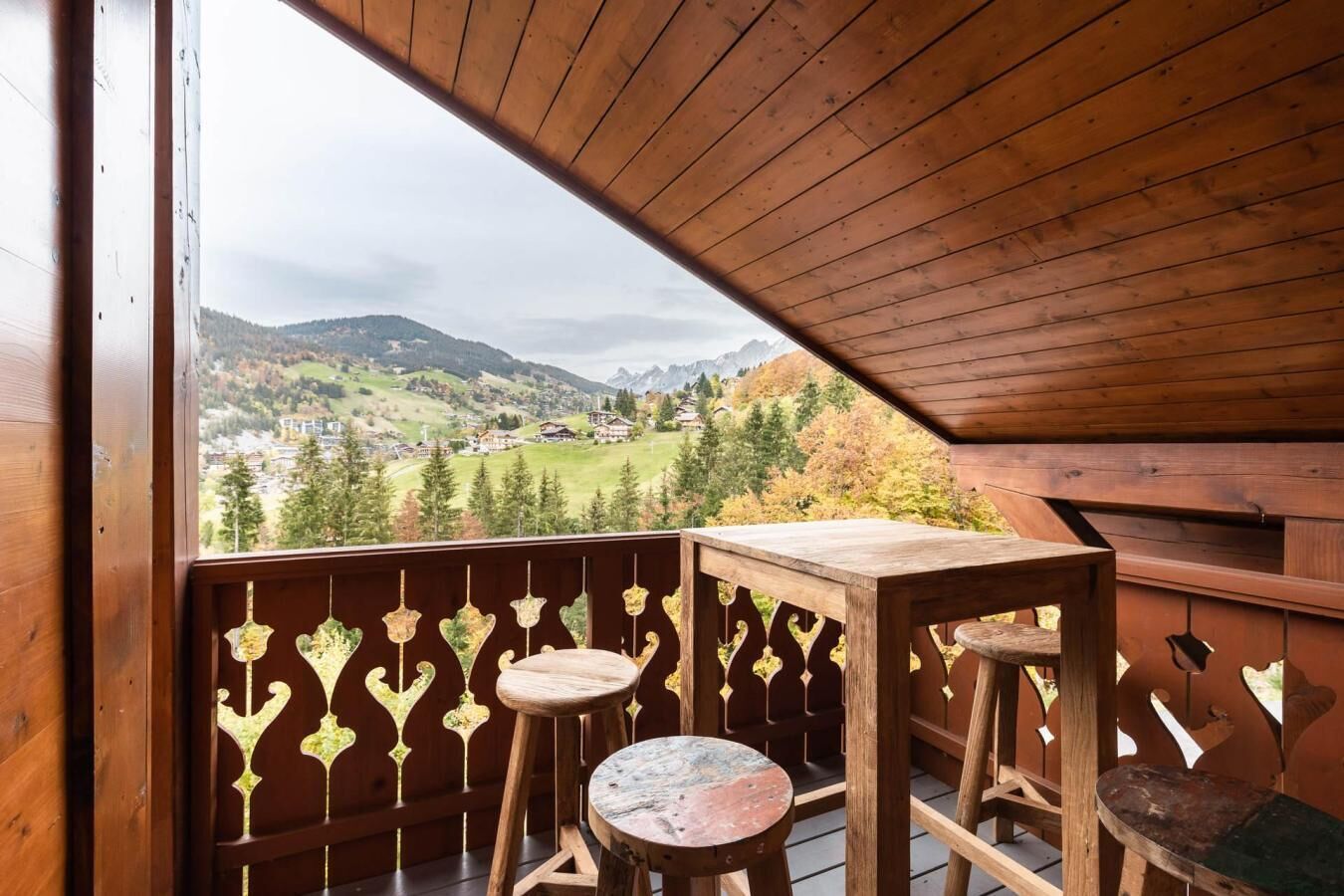 A wooden balcony with a view of a mountainous landscape.