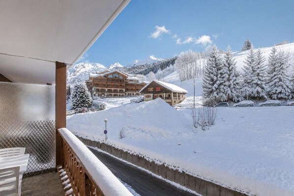 A snow-covered landscape with a wooden building and a clear sky.