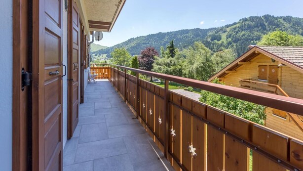 Ein Holzbalkon mit Blick auf eine Berglandschaft.
