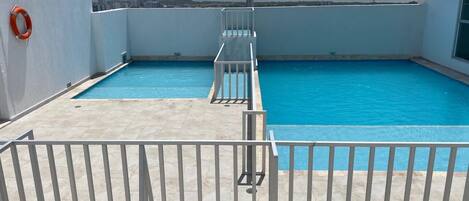 A rooftop swimming pool with a clear view of the city skyline.