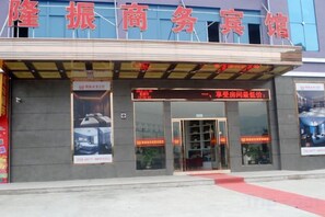 A hotel entrance with a red awning and signage in a foreign language. - Longzhen Business Hotel (Wenzhou)
