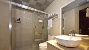 Ein modernes Badezimmer mit einer gläsernen Duschkabine, einer weißen Toilette und einem großzügigen Waschtisch.