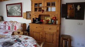 A cozy bedroom with a bed, wooden dresser, and a wall-mounted mirror. - 2nd floor, balcony, parking, tv, ski locker, 40m², Valloire (Valloire)