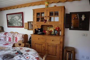 Ein gemütliches Schlafzimmer mit einem Bett, einer Holzkommode und einem an der Wand befestigten Spiegel.
