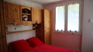 A bedroom with a bed, wooden cabinets, a window, and a radiator. - 2nd floor, balcony, parking, tv, ski locker, 40m², Valloire (Valloire)