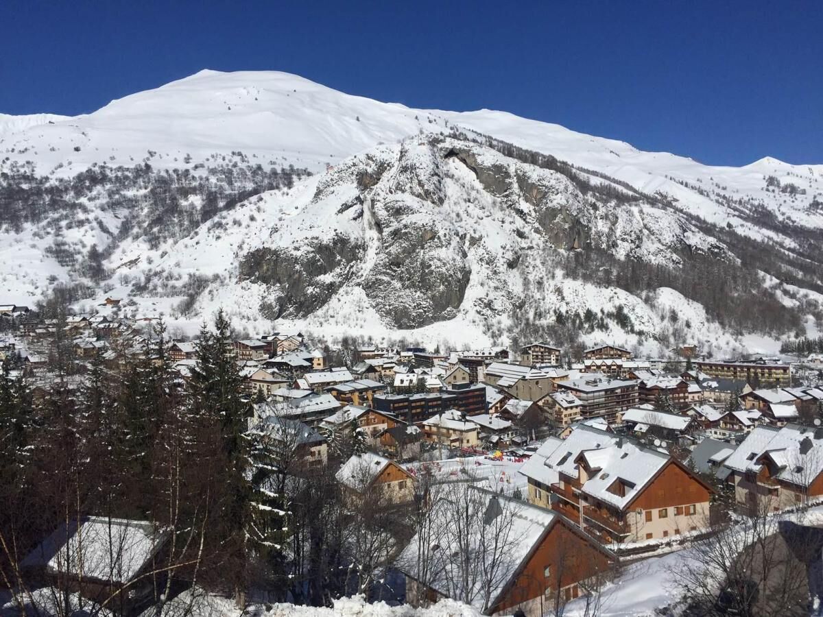 Un pueblo cubierto de nieve con edificios tradicionales de madera y un cielo azul despejado.