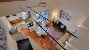 Ein geräumiger Wohnbereich mit Esstisch, einer Couch und einer Treppe, die zu einer oberen Etage führt.