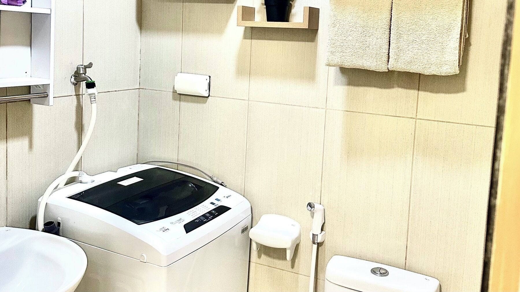 A bathroom with a white bathtub, a toilet, a sink, and a towel rack.