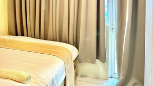 Ein Schlafzimmer mit Bett, Vorhängen und hängenden Pendelleuchten.