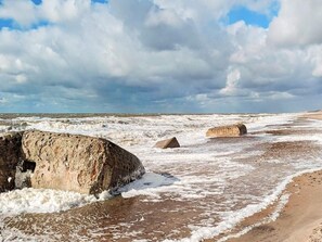 A beach with large rocks and waves.