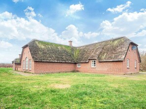 A large brick building with a thatched roof, a chimney, and a satellite dish. - 4 Star Holiday Home in Ulfborg (Ulfborg)