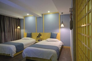 A hotel room with two single beds, a nightstand, a lamp, and a yellow partition wall. - Tiantai Garden Boutique Hotel (Tongxiang)