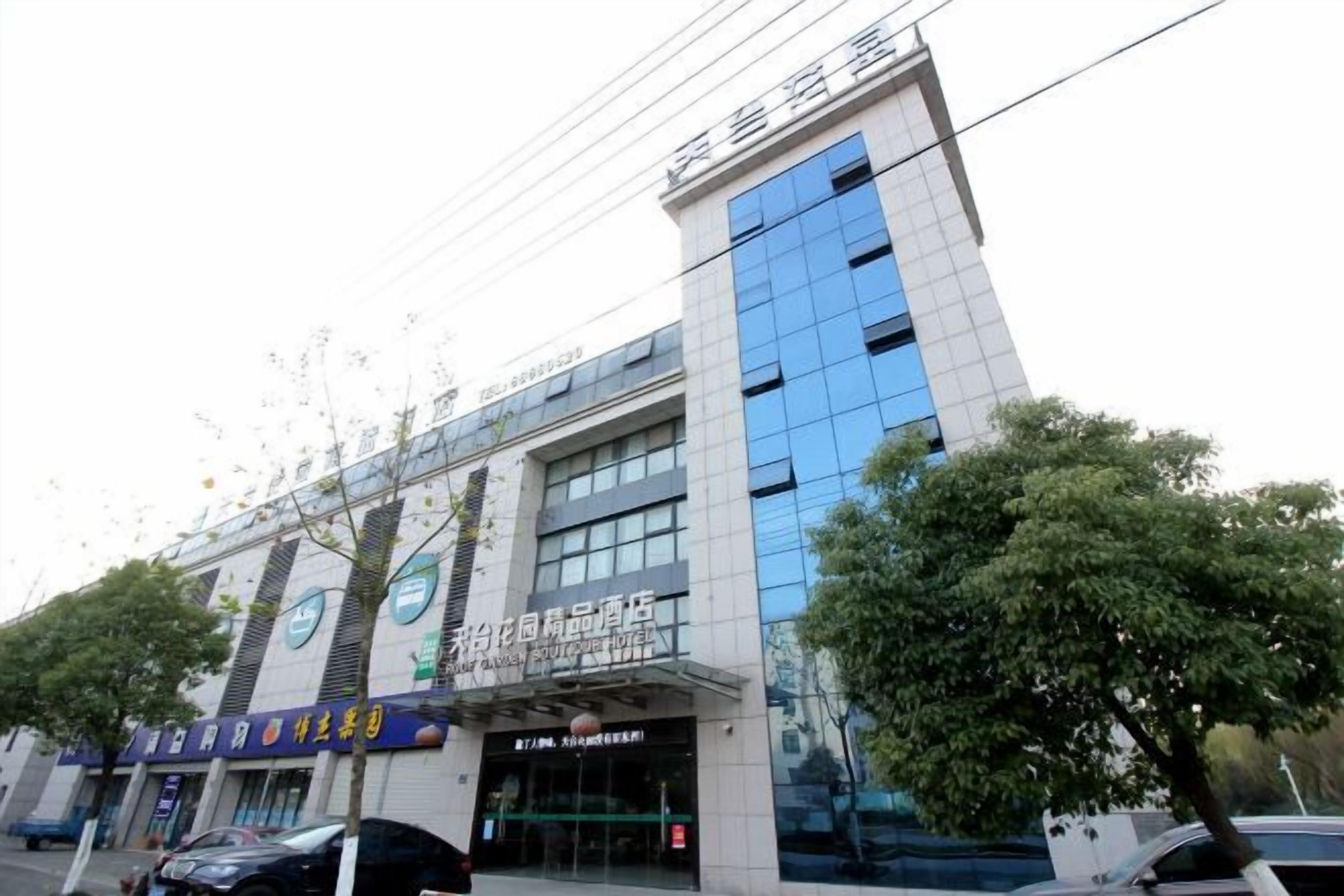 A multi-story building with a modern architectural design, featuring a prominent entrance with glass doors and signage.