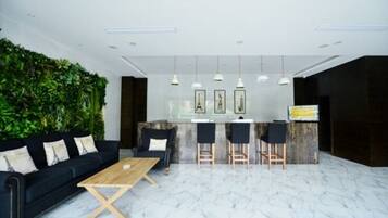 A modern interior with a black sofa, wooden coffee table, and a green wall.