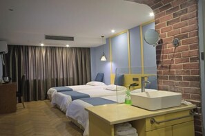 A hotel room with two beds, a wooden dresser, a sink, and a mirror. - Tiantai Garden Boutique Hotel (Tongxiang)