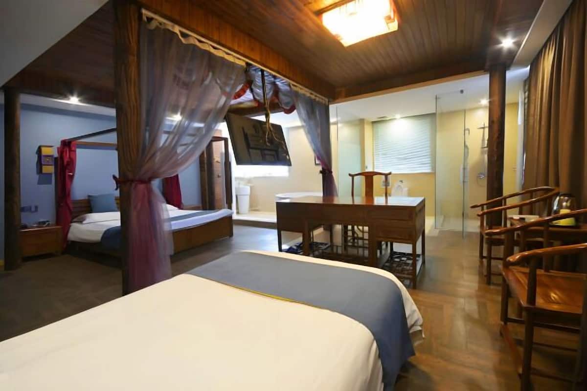 Ein Schlafzimmer mit einem Himmelsbett, einem Schreibtisch und einem Stuhl.