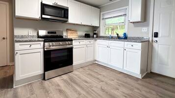 Kylskåp, grytor/köksredskap och matbord