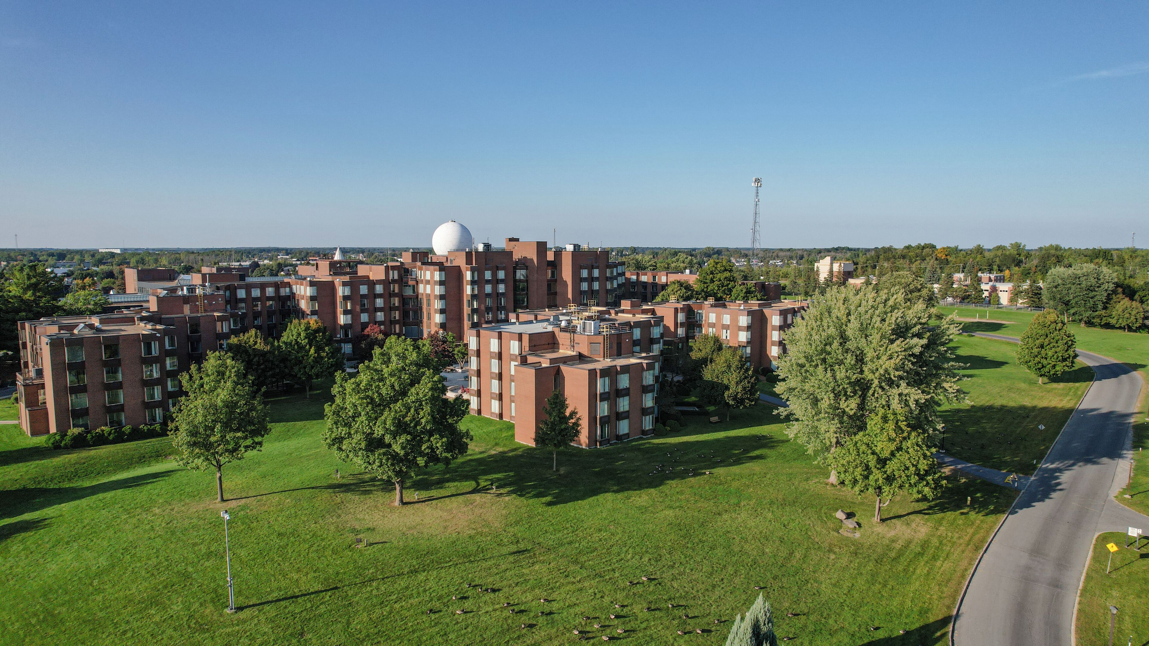 A residential complex with multiple apartment buildings, green lawns, and trees.