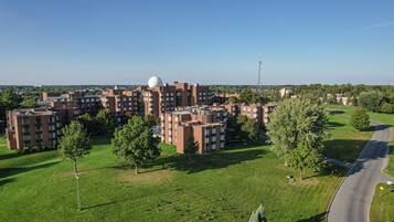 A residential complex with multiple apartment buildings, green lawns, and trees.