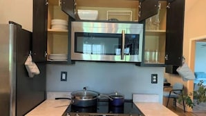 A compact kitchen with a built-in microwave, oven, and gas stove.