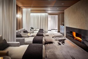 A modern living room with a fireplace, sofas, and a patterned wall.