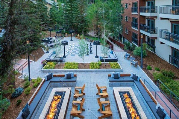 An outdoor courtyard with fire pits, seating areas, and a chessboard. - Luxury Hotel Room With King Bed in Lionshead Village (Vail)