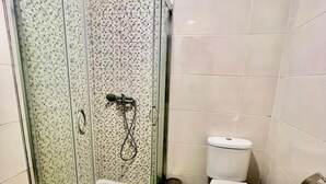 Ein Badezimmer mit Duschkabine, Toilette und Waschbecken.