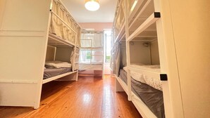A room with bunk beds, wooden flooring, and a ceiling light. - SwissPorto Guest House (Porto)