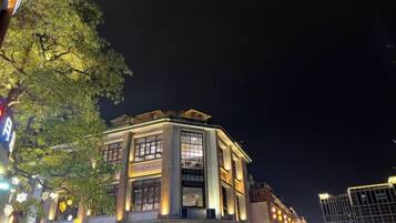 Un edificio con múltiples ventanas y un estilo arquitectónico tradicional, rodeado de otras construcciones.