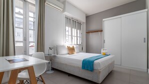 Une chambre à coucher moderne avec un lit, une table de chevet et une fenêtre avec des rideaux.