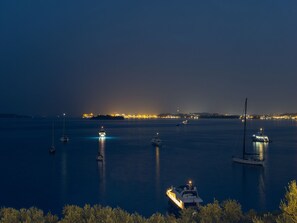Boats anchor in the tranquil harbor surrounded by lush greenery.