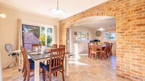 A dining area with a brick wall, a large window, and a view of the outdoors.