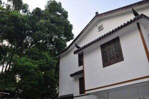 A traditional building with a tiled roof and wooden window frames. - West Lake Teavilla (Hangzhou)