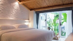 A bedroom with a wooden ceiling, a brick wall, a bed with white bedding, a window with curtains, and a view of greenery outside. - West Lake Teavilla (Hangzhou)