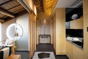 A narrow hallway leading to a kitchen with wooden cabinets and a black countertop. - West Lake Teavilla (Hangzhou)