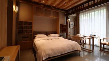 Een slaapkamer met een bed, nachtkastjes, een bureau en een stoel.