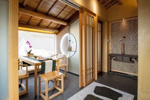 A traditional Japanese-style interior with tatami flooring, a low wooden table, and a sliding door. - West Lake Teavilla (Hangzhou)