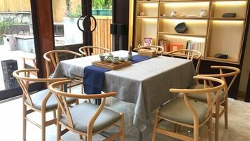 Comedor con una mesa dispuesta para cuatro personas, rodeado de sillas de madera con asientos acolchados.